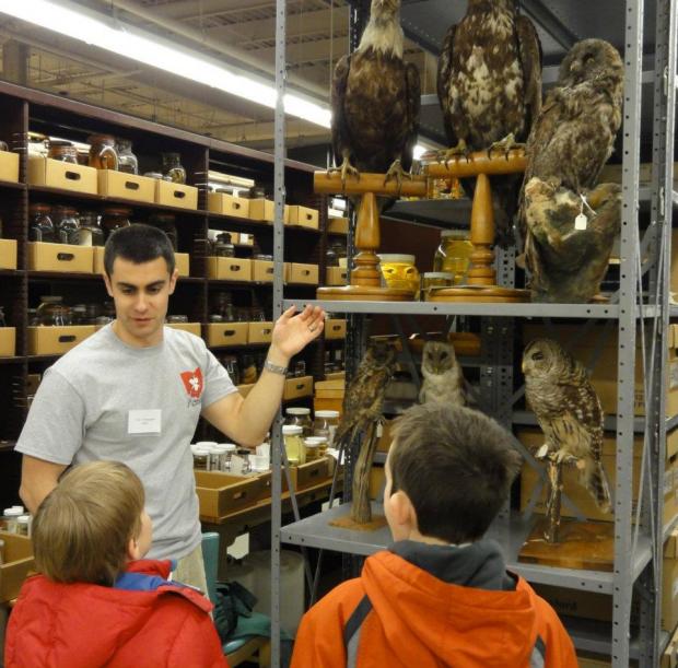 picture of a student showing specimens to visitors