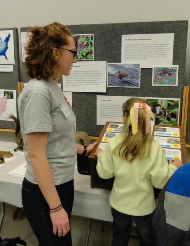 A student explains a display to a visitor