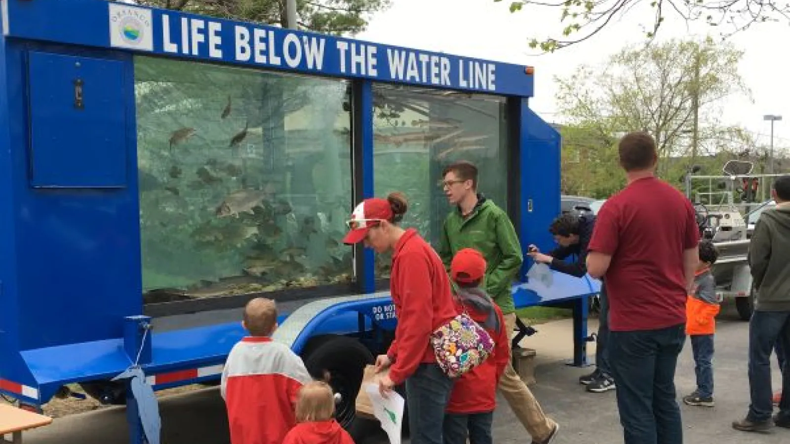 People gathered around a trailer-sized fish tank