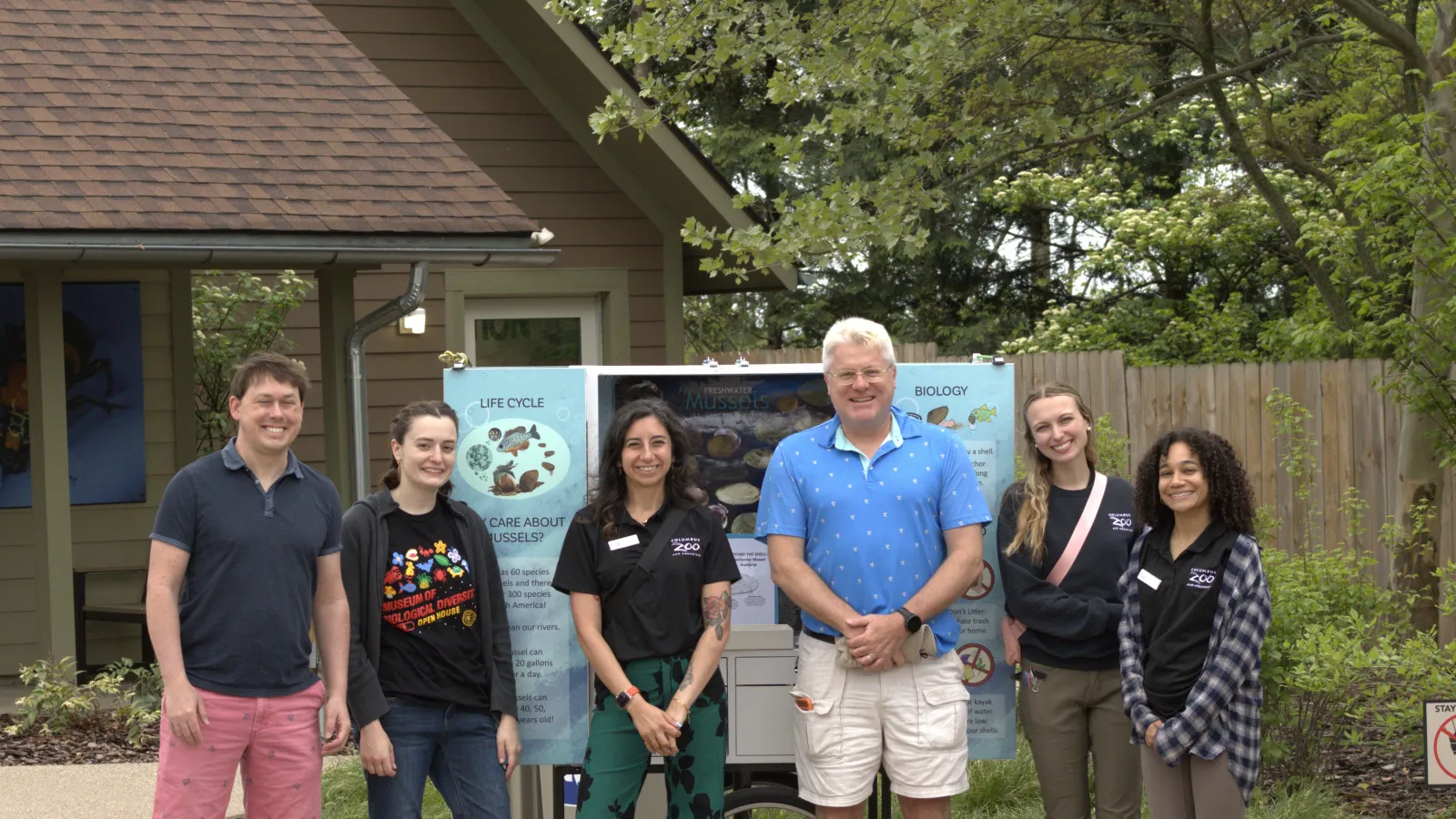 Six people standing in front of exhibit display about freshwater mussels