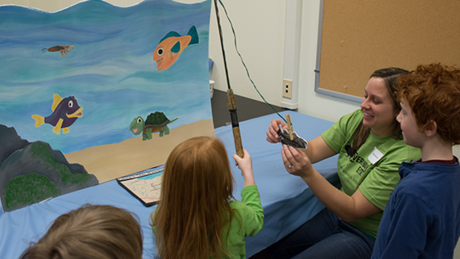 Sarah Bowman and visitors play the Fishing Game 